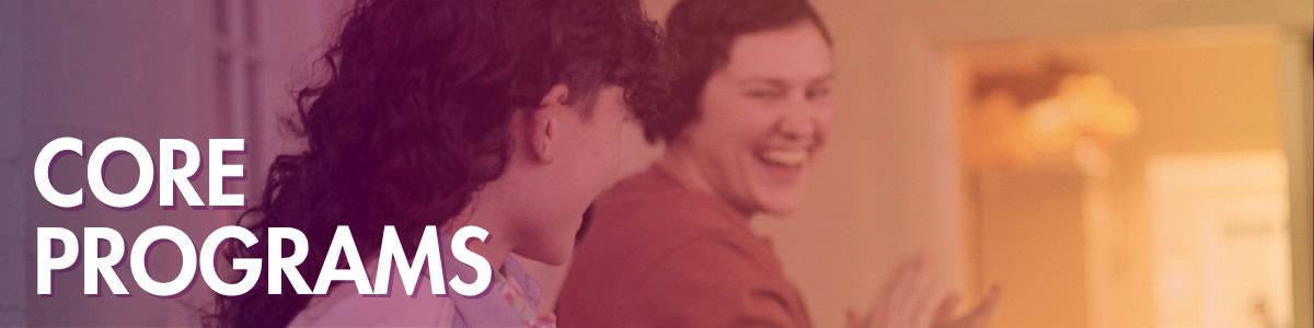 Two people smiling and laughing indoors with the words "Core Programs" in bold white text on the left side of the image.