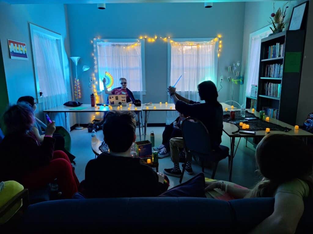 A group of youth playing D&D with blue lighting